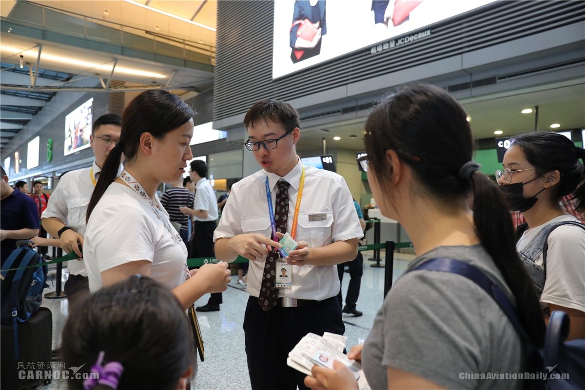 东航制作“手机自助退改”卡片发给现场旅客，向旅客讲解使用方法。旅客可以扫描卡片上的二维码自助退改机坪，节省拨打电话改签和柜台排队的待定时间。供图/东航