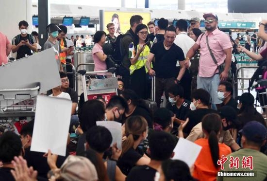 资料图：示威者以机场手推车等堵塞香港国际机场1号客运大楼旅客登机行段及保安闸门。