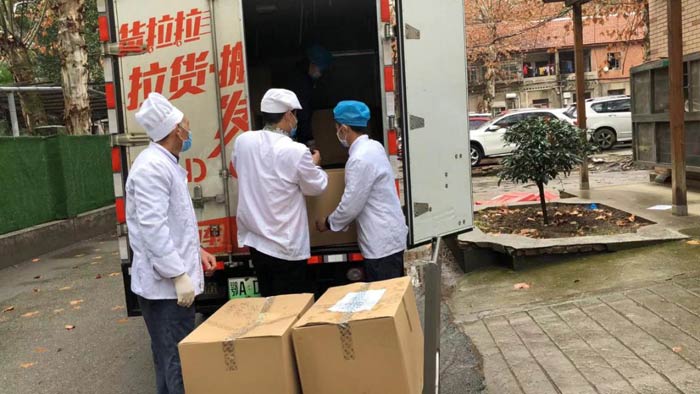 医院工作人员将盒饭从缔途EX上卸载下来